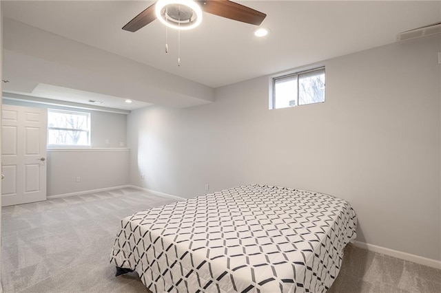 bedroom with multiple windows, light colored carpet, and baseboards