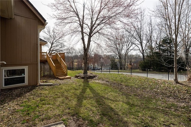 view of yard featuring a wooden deck, stairs, and fence