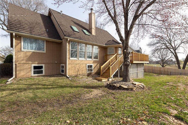 back of house with fence, a yard, a chimney, stairs, and a deck