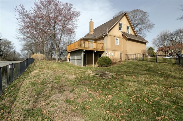 back of house featuring a chimney, a yard, and fence