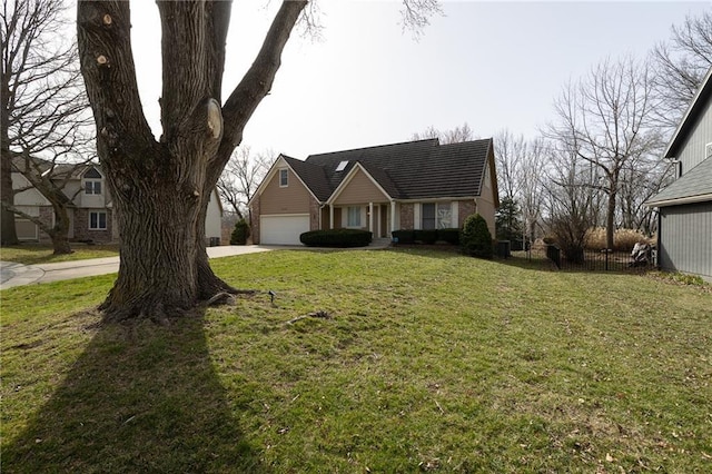 view of front of home with an attached garage, concrete driveway, a front lawn, and fence