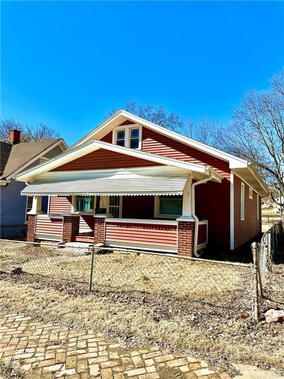 bungalow-style house featuring covered porch and fence