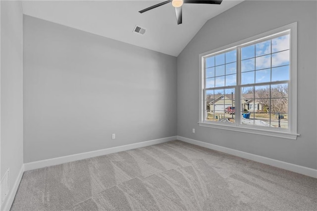 spare room featuring lofted ceiling, carpet flooring, visible vents, and baseboards