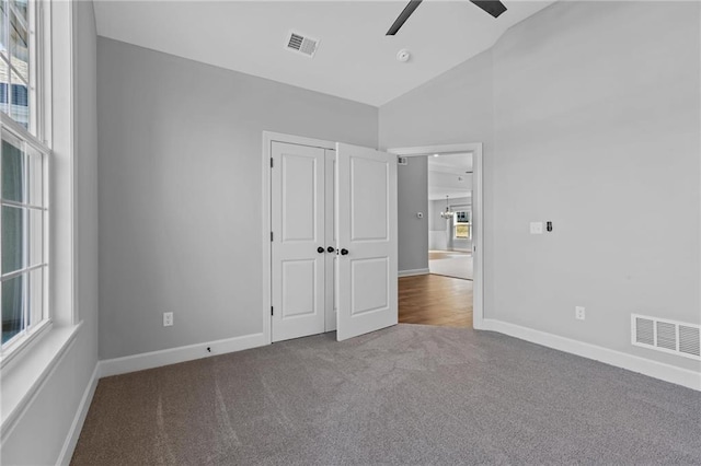 unfurnished bedroom featuring vaulted ceiling, carpet, visible vents, and baseboards