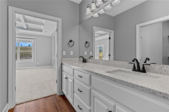 full bath featuring baseboards, coffered ceiling, a sink, and wood finished floors