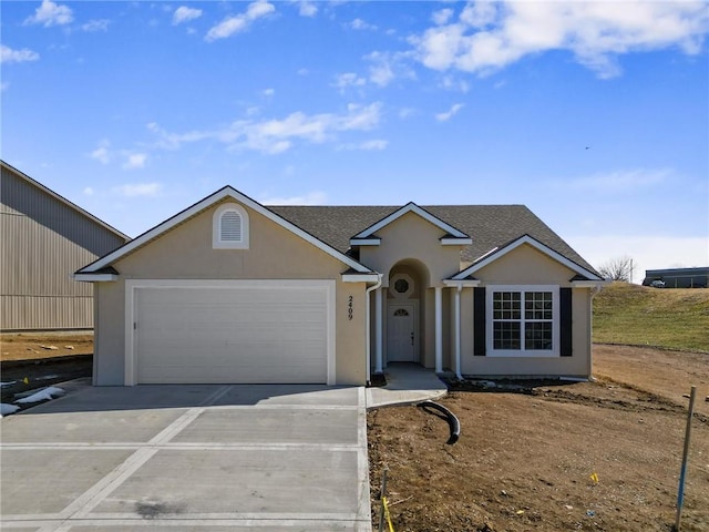 ranch-style house with concrete driveway, a shingled roof, an attached garage, and stucco siding