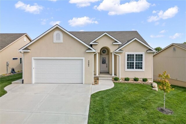 2409 Merlot Pl, Excelsior Springs, MO 64024 - traditional-style home featuring an attached garage, driveway, a front yard, and stucco siding