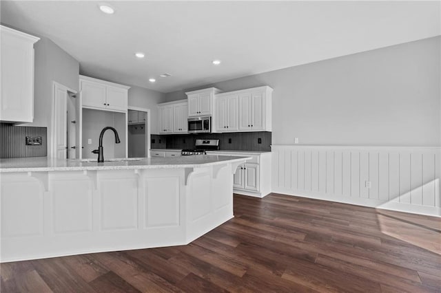 2409 Merlot Pl, Excelsior Springs, MO 64024 - kitchen with stainless steel appliances, dark wood-style floors, a kitchen bar, decorative backsplash, and recessed lighting
