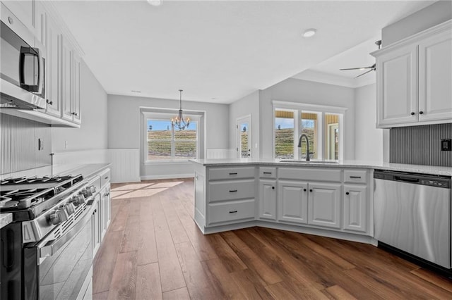 2409 Merlot Pl, Excelsior Springs, MO 64024 - kitchen with appliances with stainless steel finishes, dark wood-style flooring, a chandelier, white cabinets, and recessed lighting