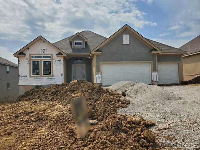 unfinished property with roof with shingles and a garage