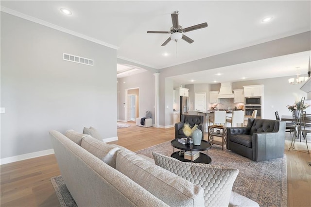 living area with visible vents, baseboards, a ceiling fan, crown molding, and recessed lighting
