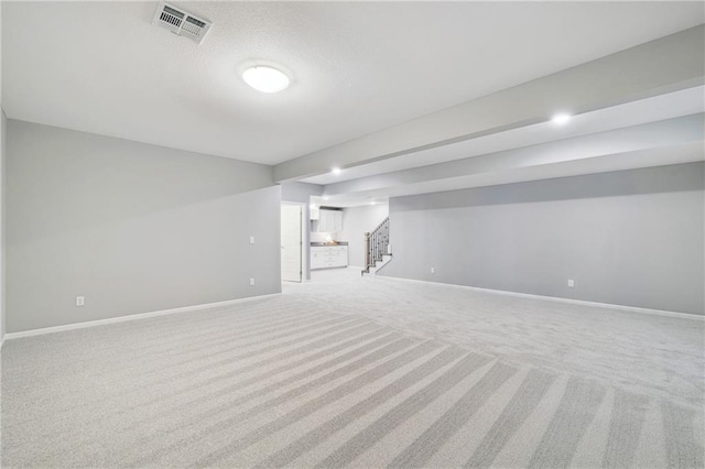 interior space with visible vents, baseboards, carpet, and stairs