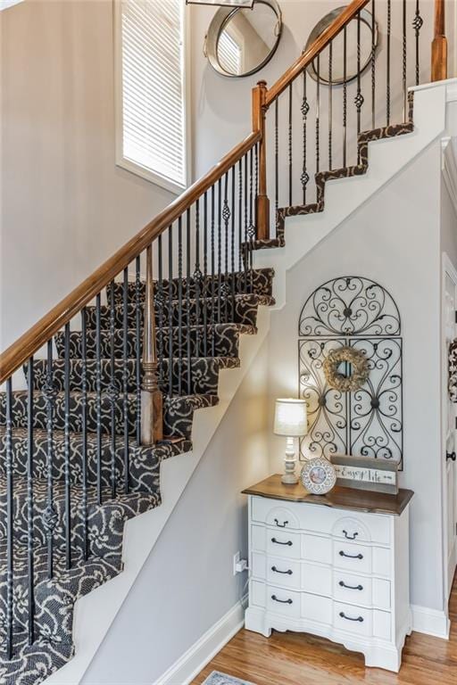 stairway with baseboards and wood finished floors