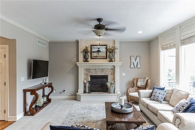 carpeted living area with ornamental molding, visible vents, a fireplace, and baseboards