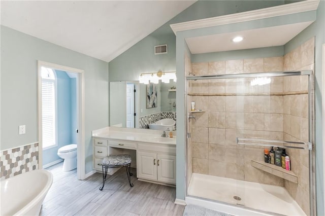 full bathroom featuring lofted ceiling, toilet, vanity, visible vents, and a shower stall