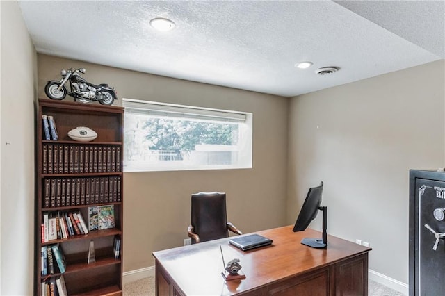 office with a textured ceiling, baseboards, visible vents, and light colored carpet