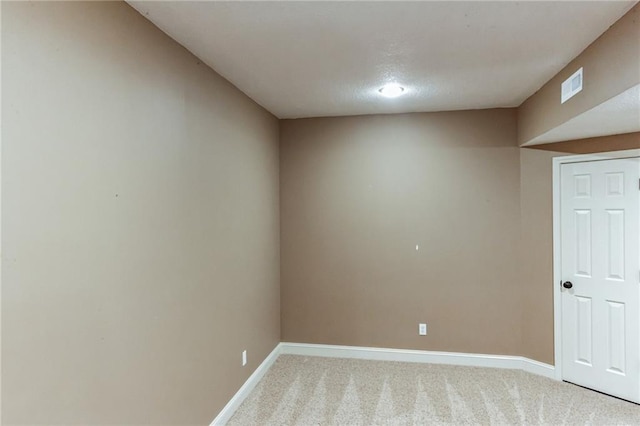 spare room featuring light carpet, visible vents, and baseboards