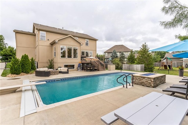 view of pool featuring a patio, fence, stairway, a fenced in pool, and an outdoor living space with a fire pit