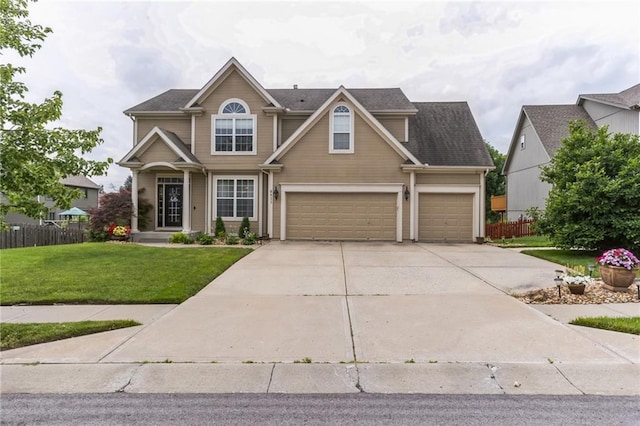 view of front of property with a garage, a front yard, concrete driveway, and fence