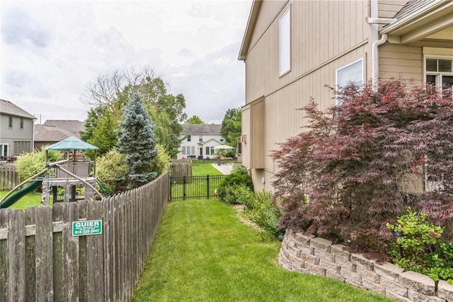 view of yard featuring playground community, fence, and a residential view