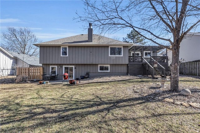 rear view of property with a deck, a patio, fence, stairway, and a chimney