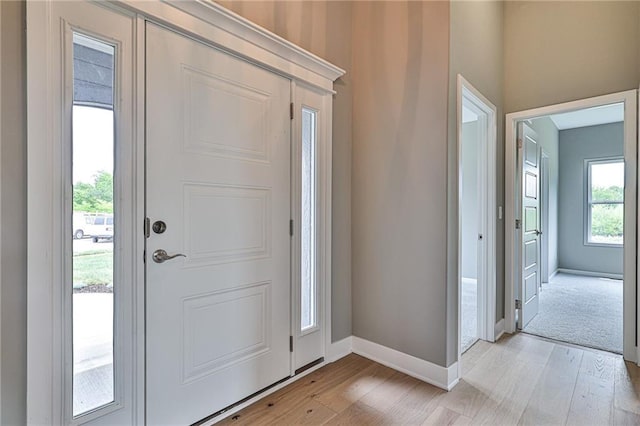 entryway with light wood-style flooring and baseboards