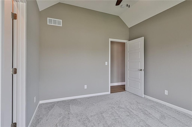unfurnished room with ceiling fan, vaulted ceiling, visible vents, carpet floors, and baseboards