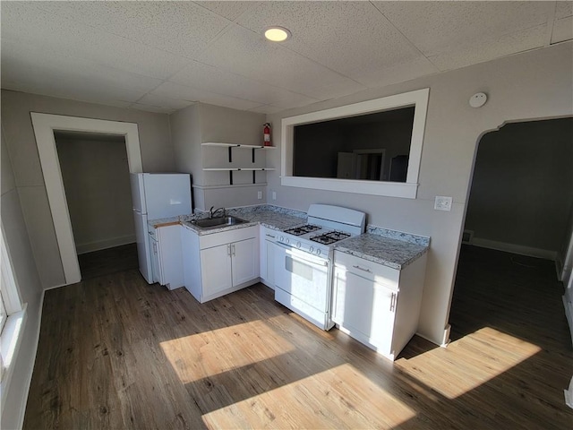 kitchen featuring white appliances, light wood finished floors, white cabinetry, open shelves, and a sink