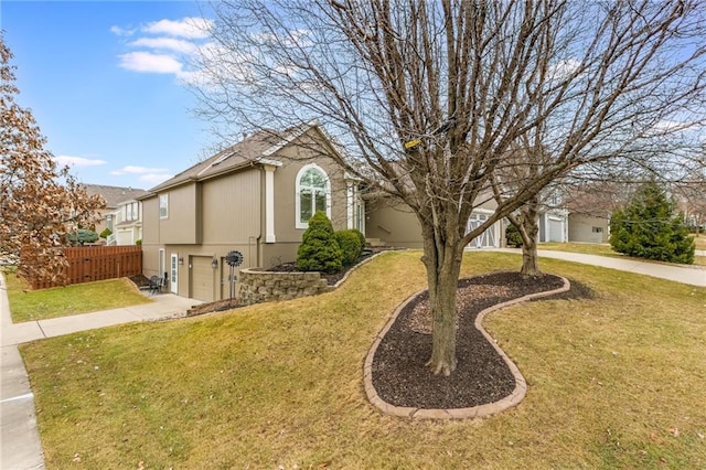 exterior space featuring a lawn, driveway, an attached garage, and fence