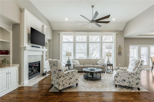 living room with recessed lighting, dark wood-style floors, a fireplace, and vaulted ceiling