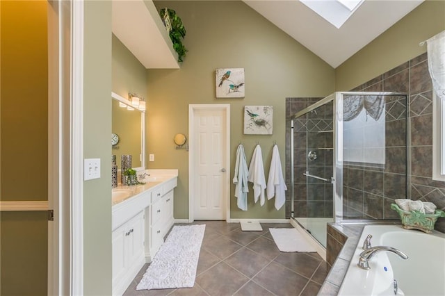 full bathroom featuring a stall shower, vaulted ceiling with skylight, tile patterned flooring, double vanity, and a bath