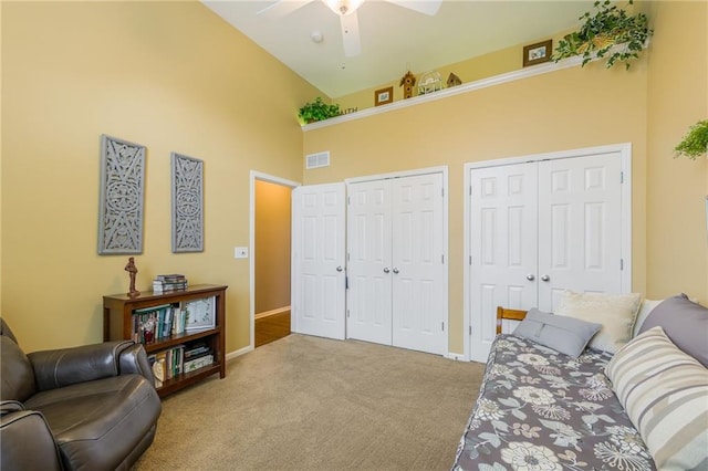 living area with carpet flooring, ceiling fan, high vaulted ceiling, and visible vents