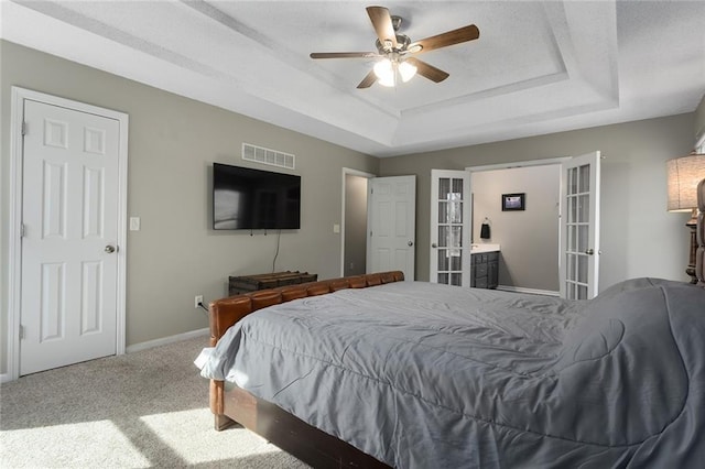 carpeted bedroom featuring french doors, a raised ceiling, visible vents, ceiling fan, and baseboards