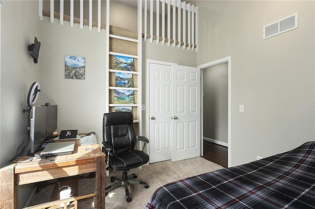 carpeted bedroom featuring a closet and visible vents