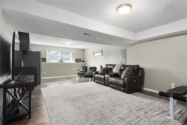 cinema with electric panel, baseboards, visible vents, dark wood-style flooring, and a textured ceiling