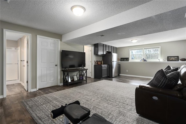 living room with dark wood-style floors, a textured ceiling, and baseboards