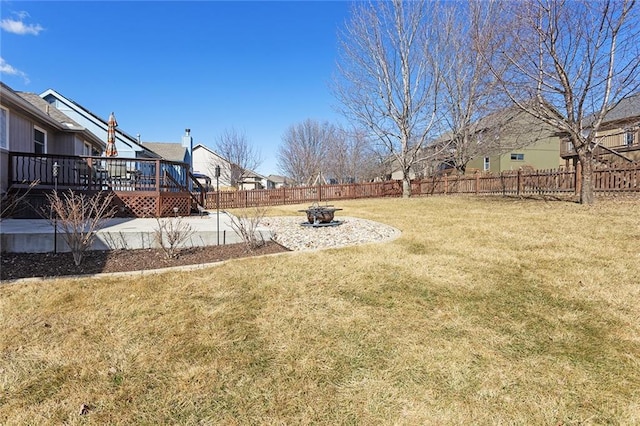 view of yard with a fire pit, a fenced backyard, a patio, and a deck