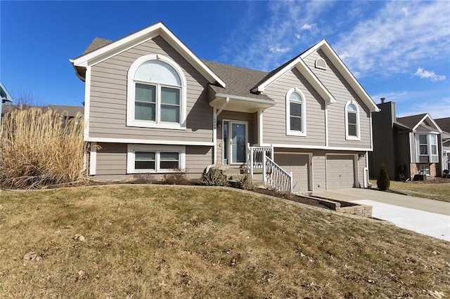 bi-level home featuring driveway, an attached garage, and a front lawn