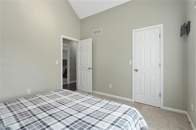 bedroom featuring light carpet, baseboards, visible vents, and lofted ceiling