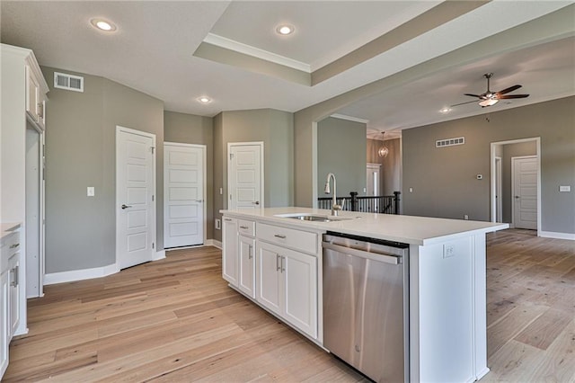 kitchen with white cabinets, a kitchen island with sink, light countertops, stainless steel dishwasher, and a sink