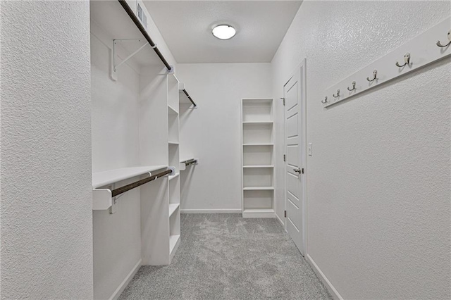 walk in closet featuring light colored carpet