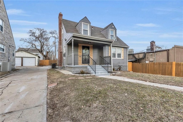 view of front of property featuring an outbuilding, central AC, a detached garage, and fence