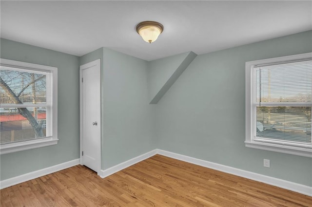 bonus room featuring light wood-style floors and baseboards