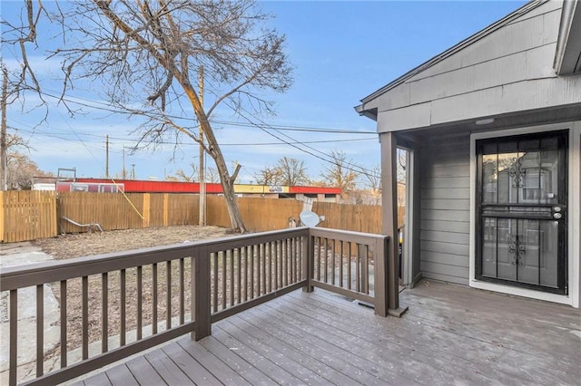 wooden terrace with a fenced backyard