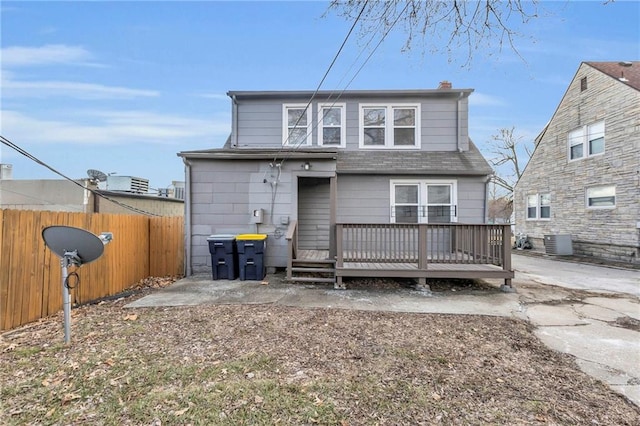 rear view of property with fence, a deck, and central AC unit