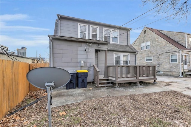 rear view of house with a deck and fence