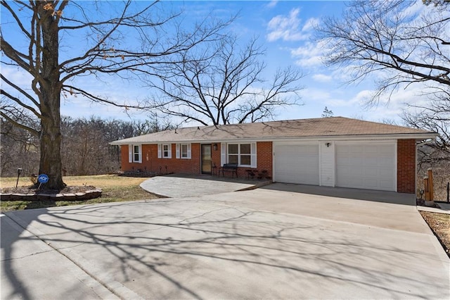 ranch-style home featuring a garage, brick siding, and driveway