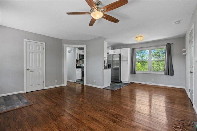 904 E Golf Hill Dr, Excelsior Springs, MO 64024 - unfurnished living room featuring ceiling fan, dark wood finished floors, and baseboards