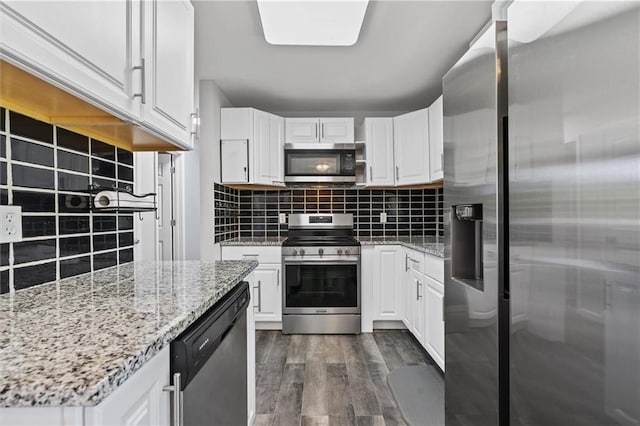 904 E Golf Hill Dr, Excelsior Springs, MO 64024 - kitchen featuring stainless steel appliances, dark wood-style flooring, white cabinetry, tasteful backsplash, and light stone counters