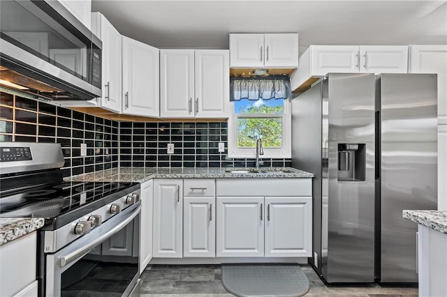 904 E Golf Hill Dr, Excelsior Springs, MO 64024 - kitchen featuring stainless steel appliances, a sink, white cabinetry, and backsplash
